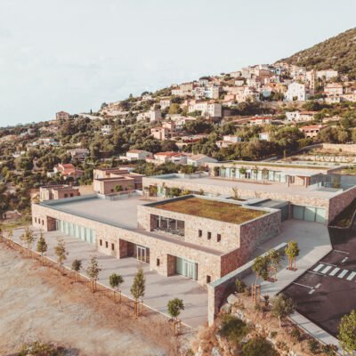 A escola esculpida em granito por Amélia Tavella se molda às curvas do vale na Córsega.