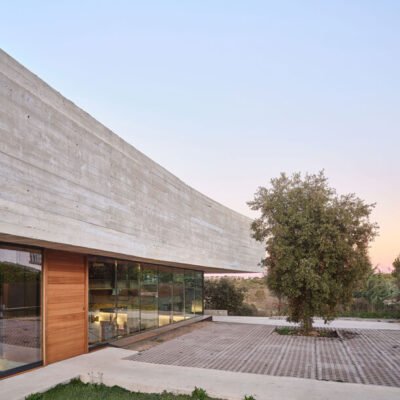 Casa Roble, envolta em concreto, se adapta ao terreno de Madri com sua fachada curva e contínua.