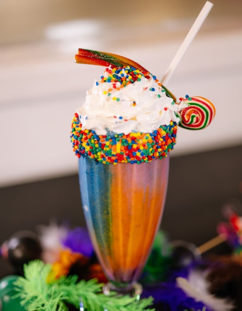 Milkshake sabor abacaxi com bolinhas e pirulito colorido em celebração ao Carnaval